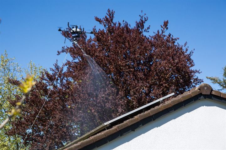 Drone pulvérisant une toiture avec panneaux solaires – démoussage